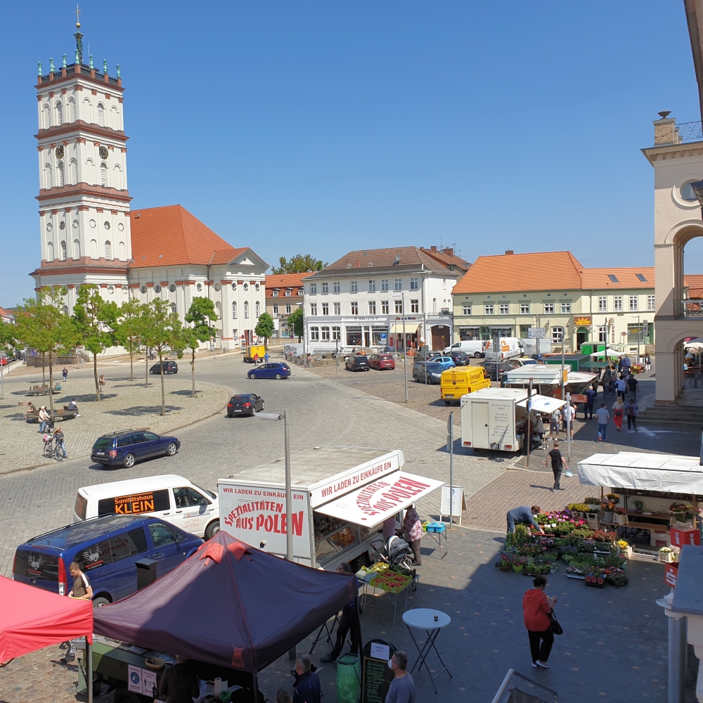 Neustrelitz, beim Rathaus mit Treiben auf dem Wochenmarkt.