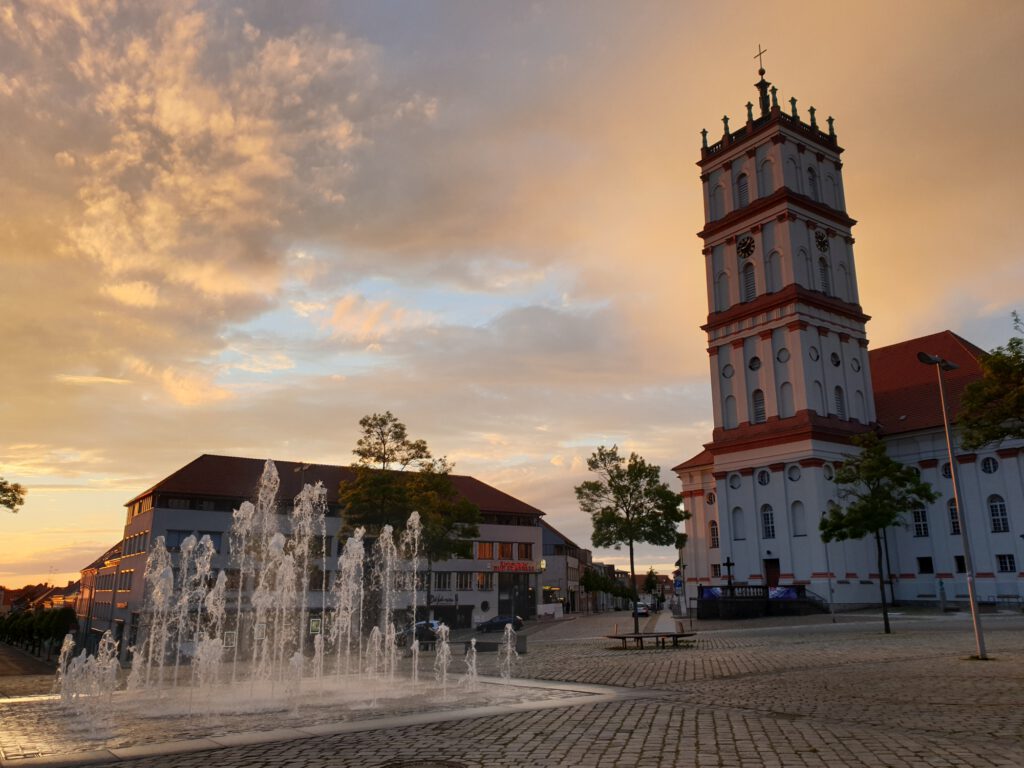Neustrelitzer Marktplatz mit Stadtkirche und Wasserspiel im Abendlicht